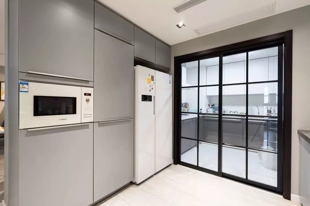 中式厨房油烟较大，用黑框玻璃门做隔断，厨房外的嵌入式家电设计，也方便日常的使用。-140㎡北欧风格装修案例，一进门就被玄关惊艳到了~